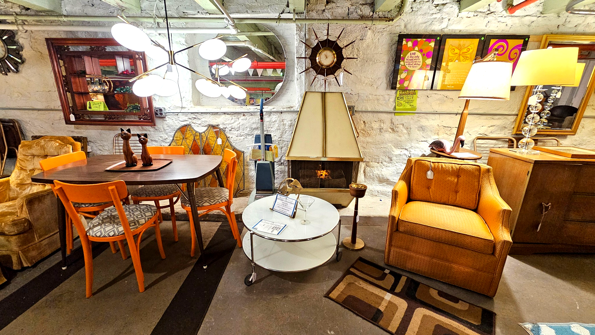 Living room with furniture and decor including a round table, chairs, and a fireplace.