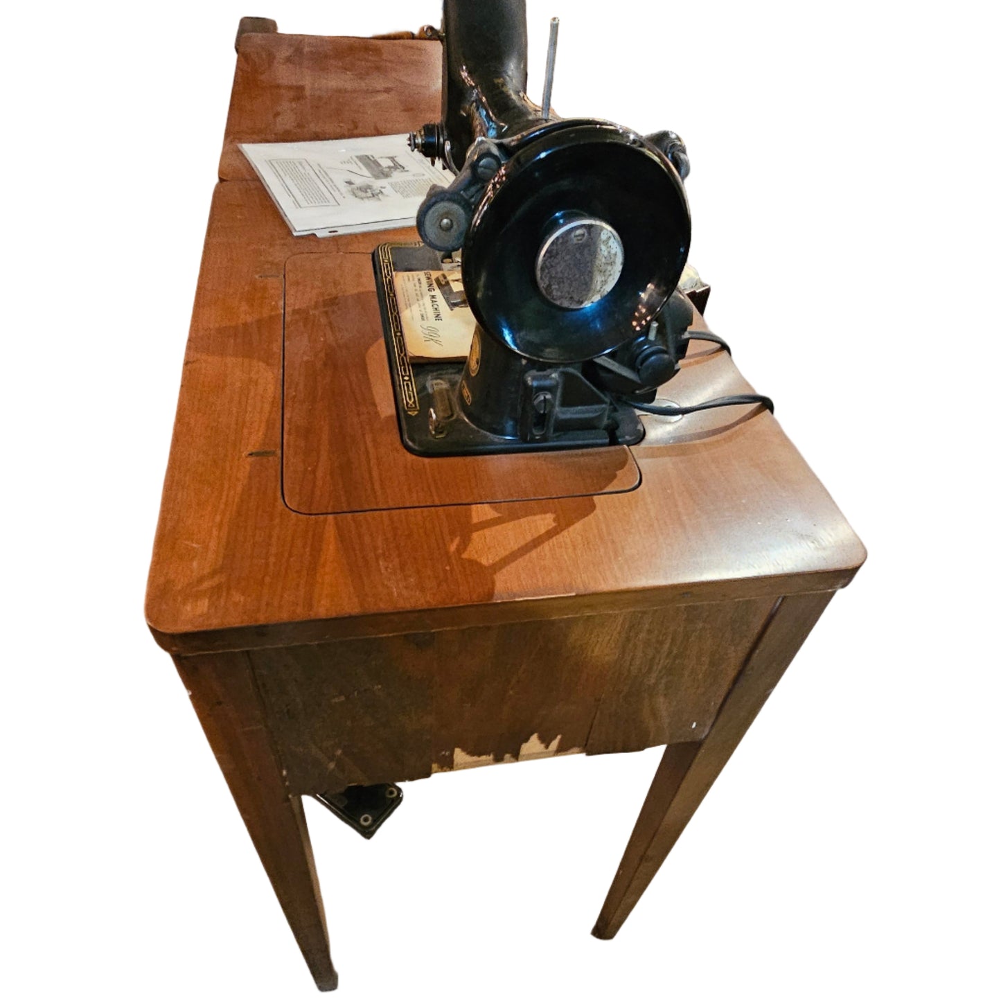 Vintage sewing machine on a wooden stand in an indoor setting